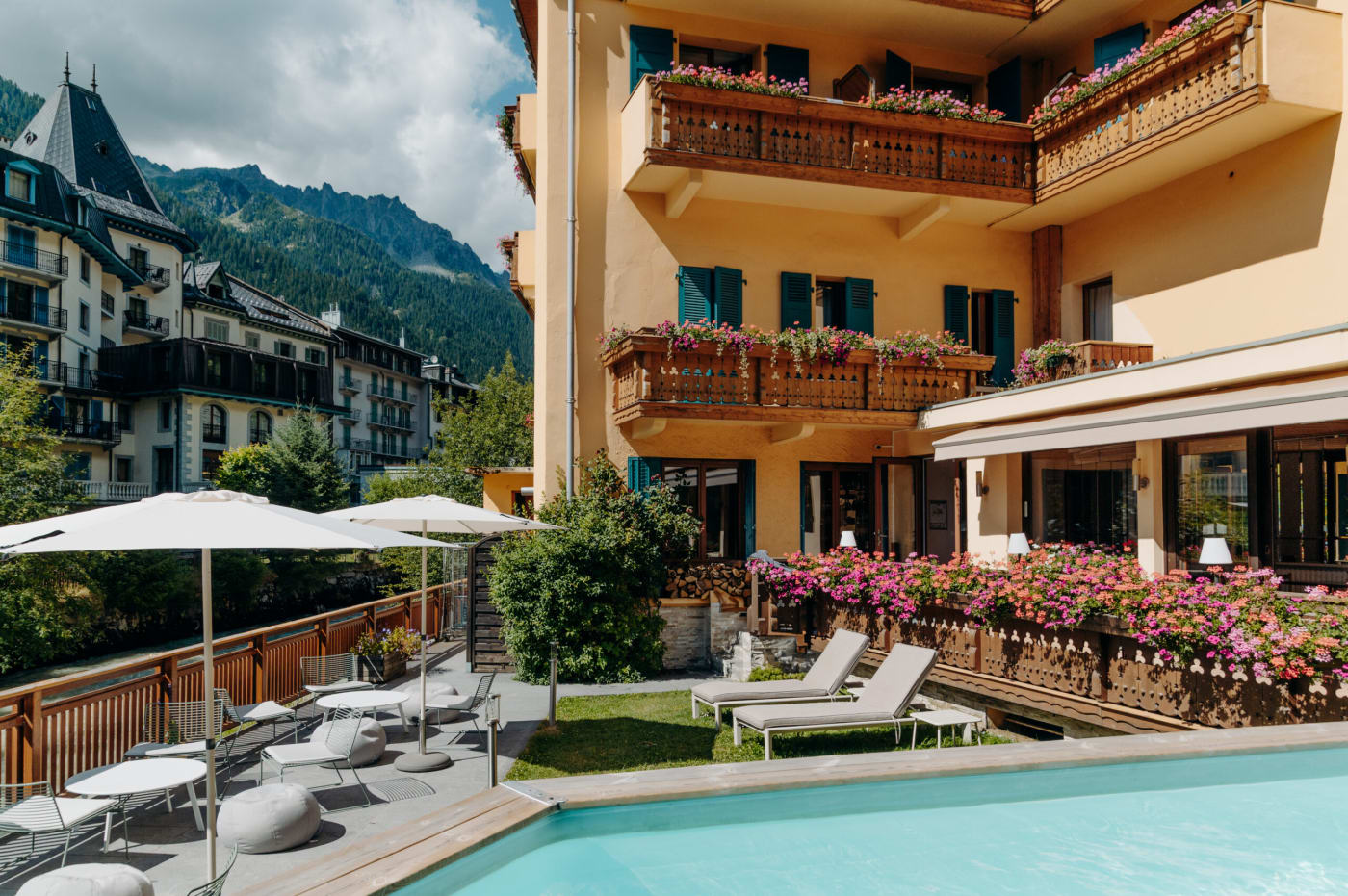 El jardín y la piscina exterior climatizada del hotel Le Lyret en verano