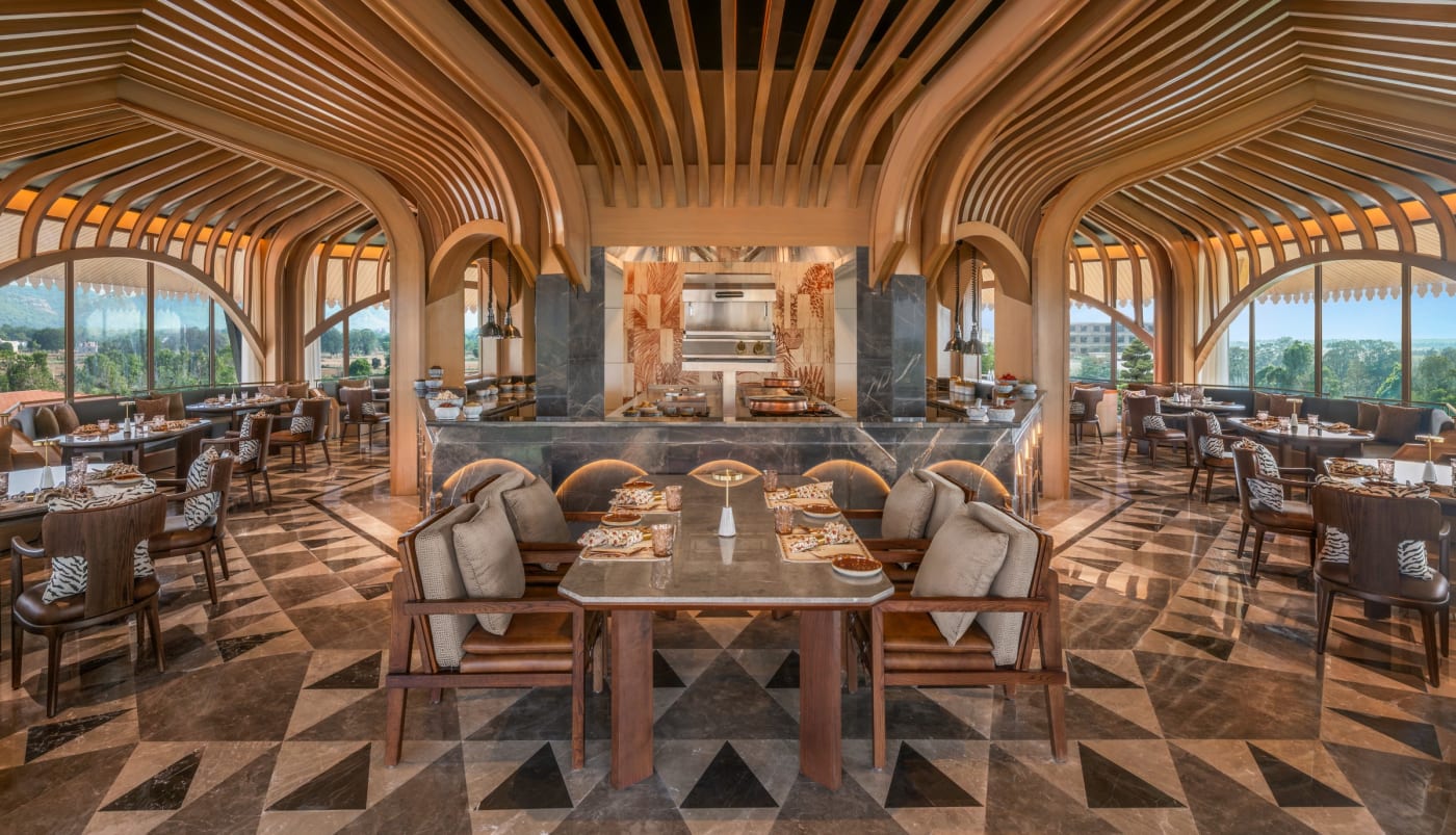 Salle du restaurant Skyloft avec charpente en bois et sol en marbre au JW Marriott Ranthambore