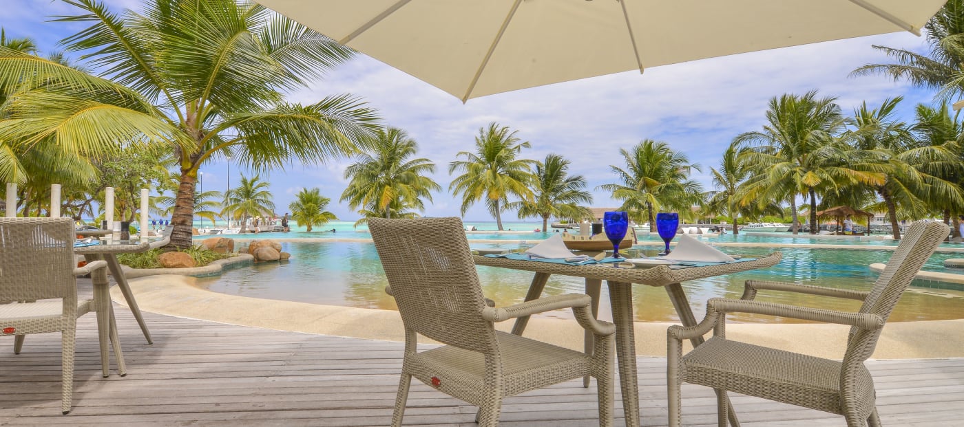 Table set on the Bokkuraa Pool Deck facing the pool at Kandooma Maldives