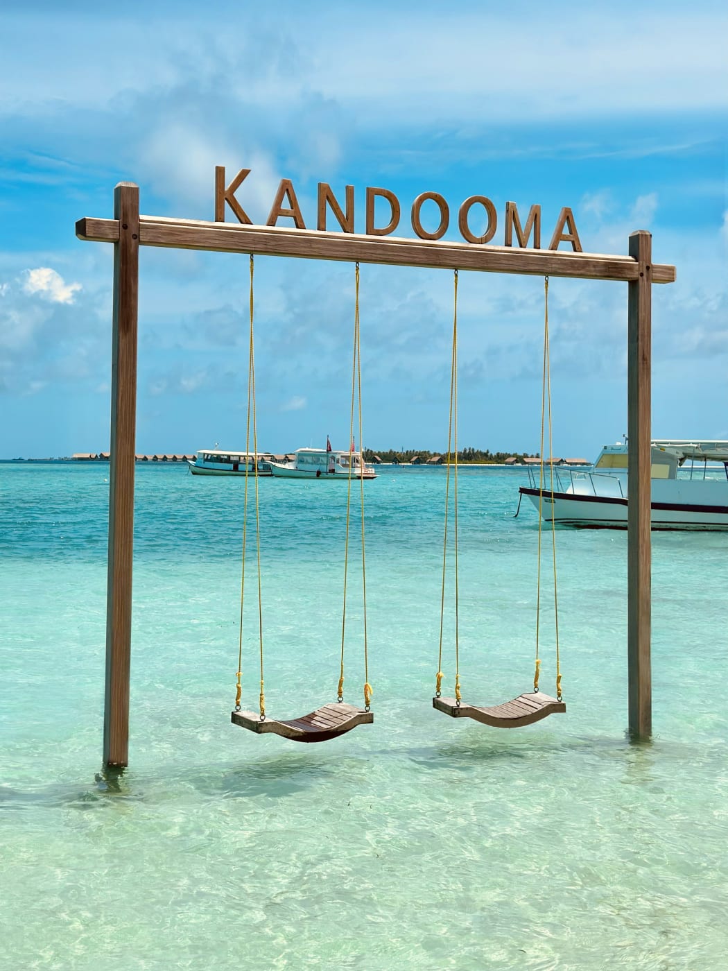 Kandooma swing set in the turquoise lagoon in front of the resort beach