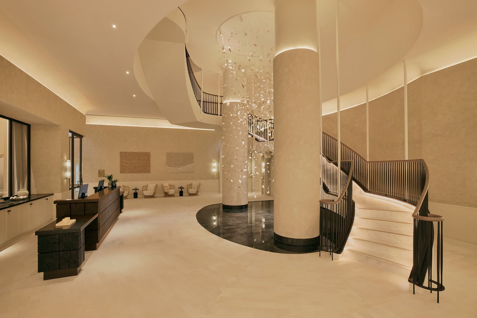 El vestíbulo del Six Senses London, columnas claras y escalera helicoidal