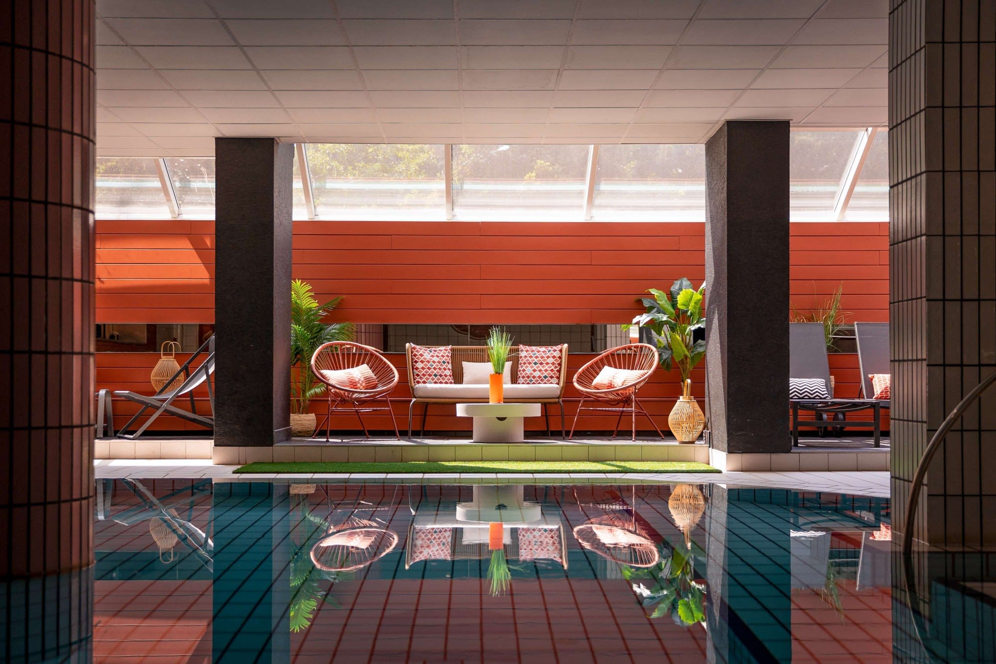 La piscine couverte, entre piliers et fauteuils · Hôtel Diana