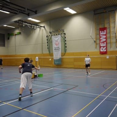 Zwei Personen spielen Badminton