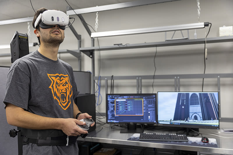 ISU student Reece Foulkrod plays Lit-VR while Assistant Professor Farjana Eishita looks on