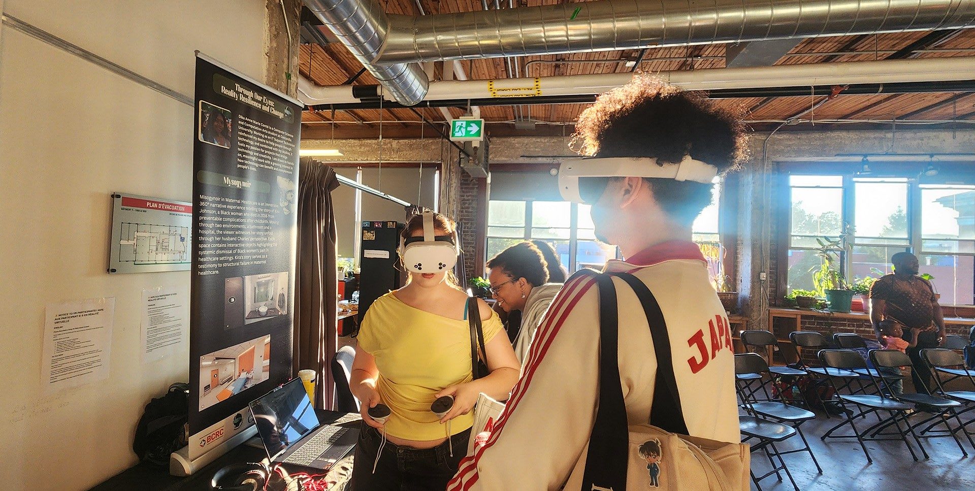 Two participants use white Meta Quest 3 headsets at a Through Our Eyes showcase, with the project display beside them.