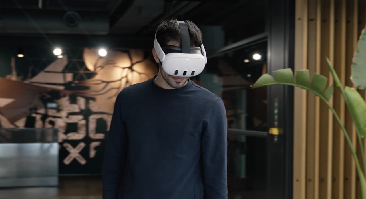 A man wearing a white standalone mixed reality headset stands in a CUPRA Garage showroom