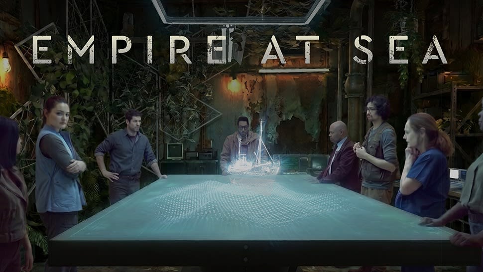Empire at Sea key art: cast members stand around a glowing LED table with a holographic boat