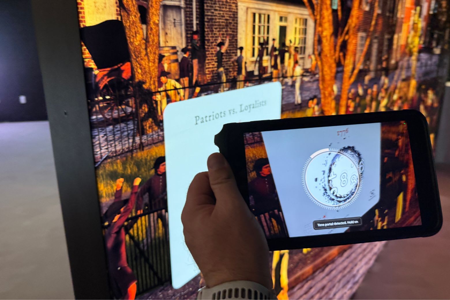 Visitor using a HistoPad tablet to scan an AR portal in the American Revolution exhibit at the National Museum of the US Army