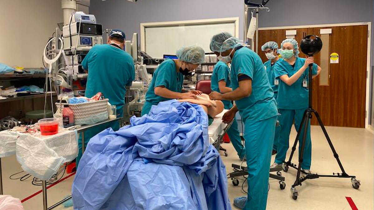 Doctors operating on test dummy.