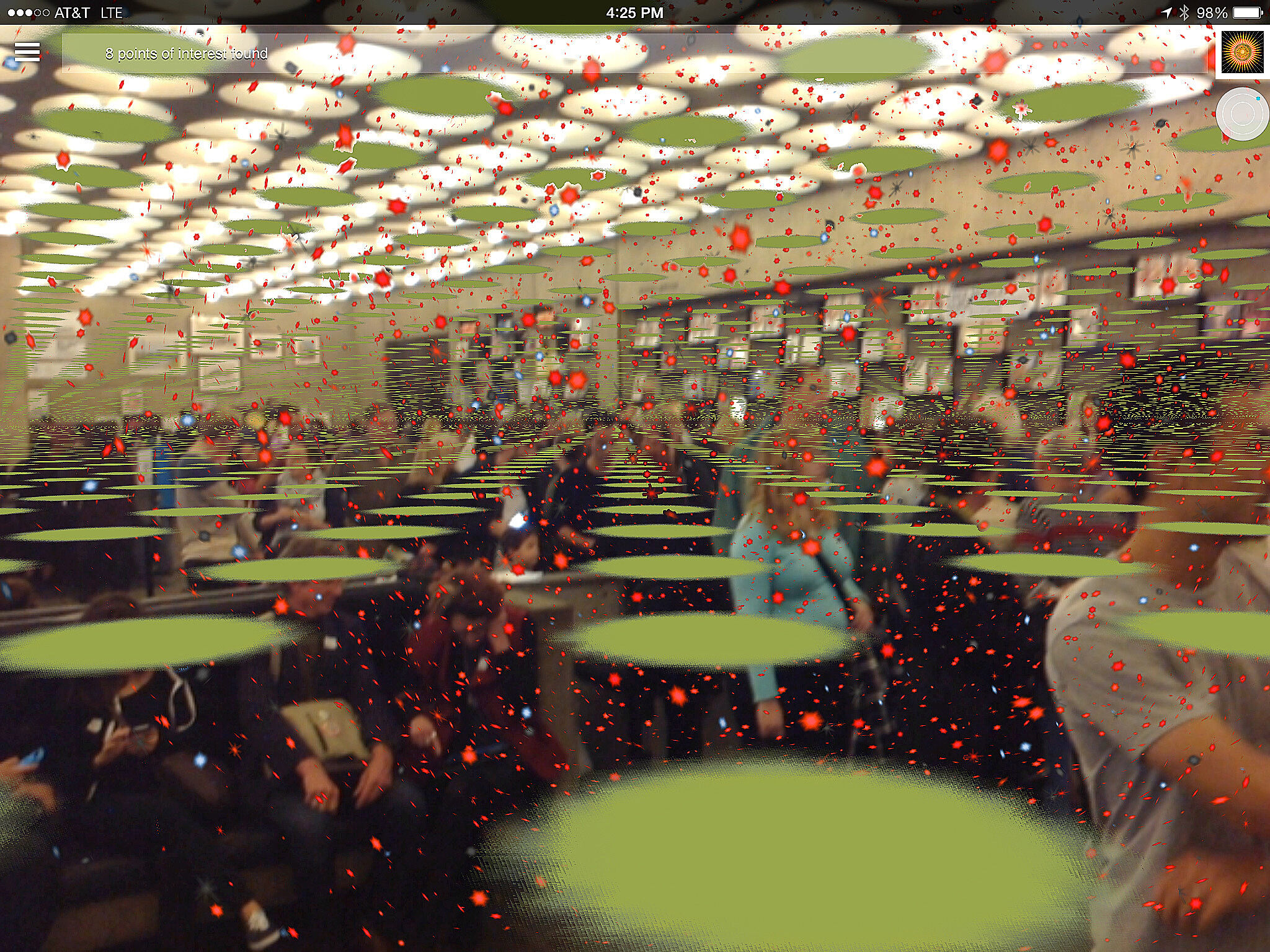 Phone screenshot of a Whitney gallery full of seated guests, overlaid with green discs and red specks by the augmented reality app
