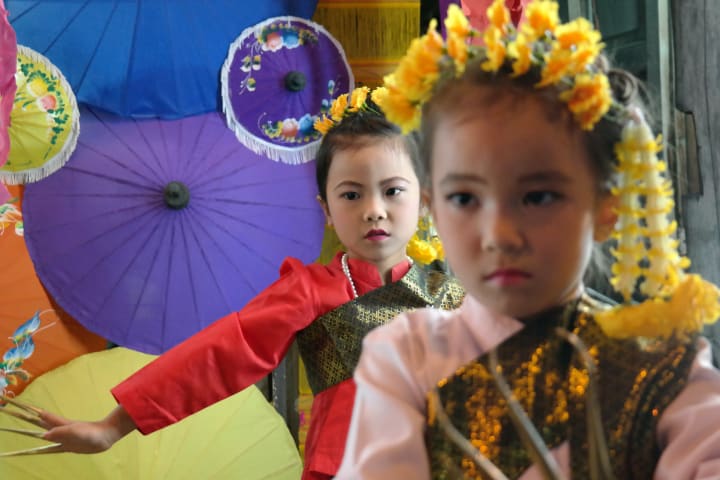 children performing at a street festival in Thailand