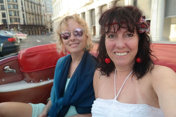mother and daughter in a cuban car smiling