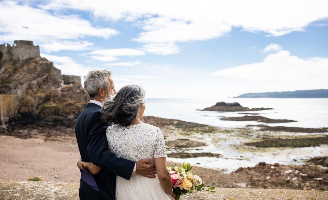 Man and Woman getting married look out to see with Elizabeth Castle in back ground