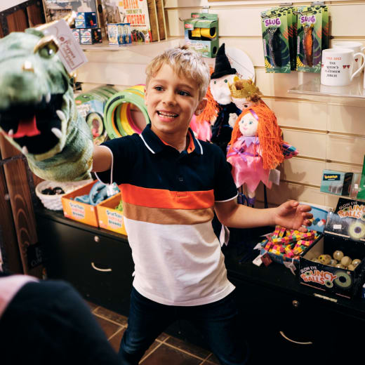 Mont Orgueil Castle child plays with puppet in shop