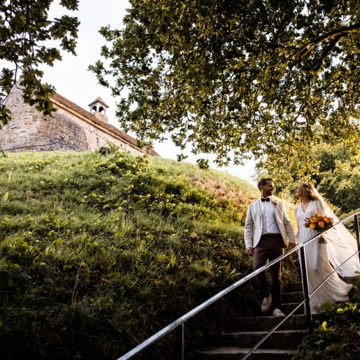 La Hougue Bie Bride and Groom Pose on Stairs with Chaple in Background