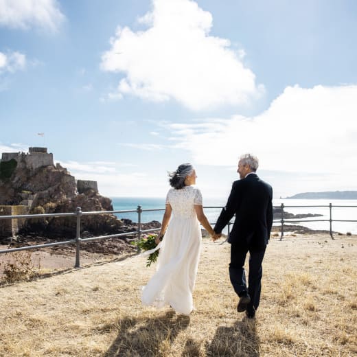 Man and Woman getting married walk towards Elizabeth Castle