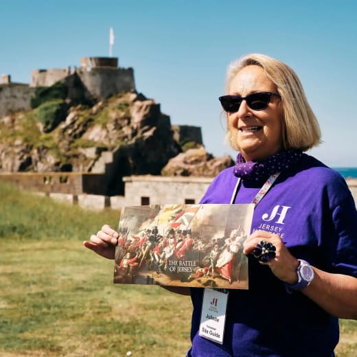 Elizabeth Castle women shows map of the Castle with Castle in background