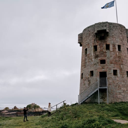 Couple take photo of large round tower with a flag flying