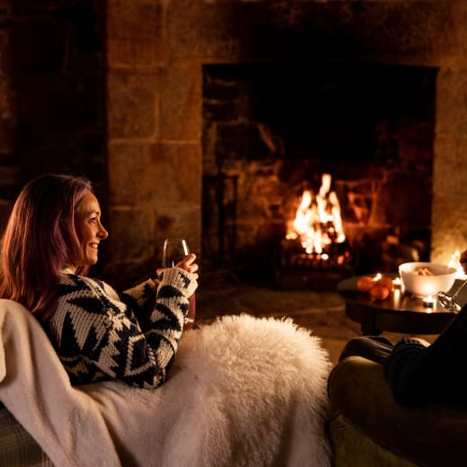 Couple relax by fireplace
