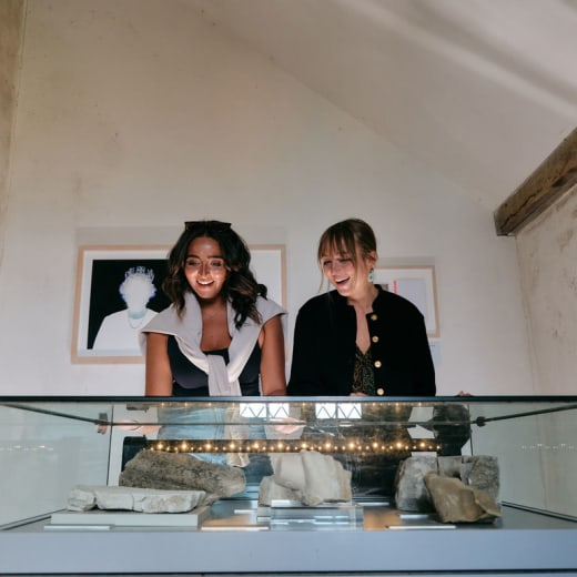 Two people look closely at an exhibition piece
