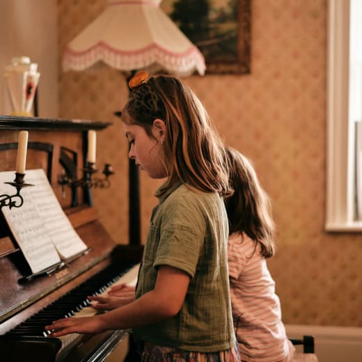 Young girls play piano