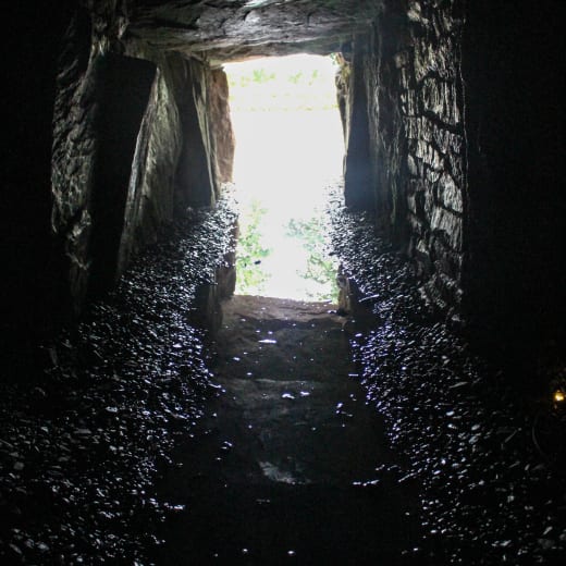 A dark stone area with light at the end