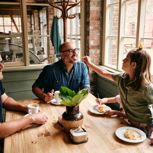 A young girl feeds her dads