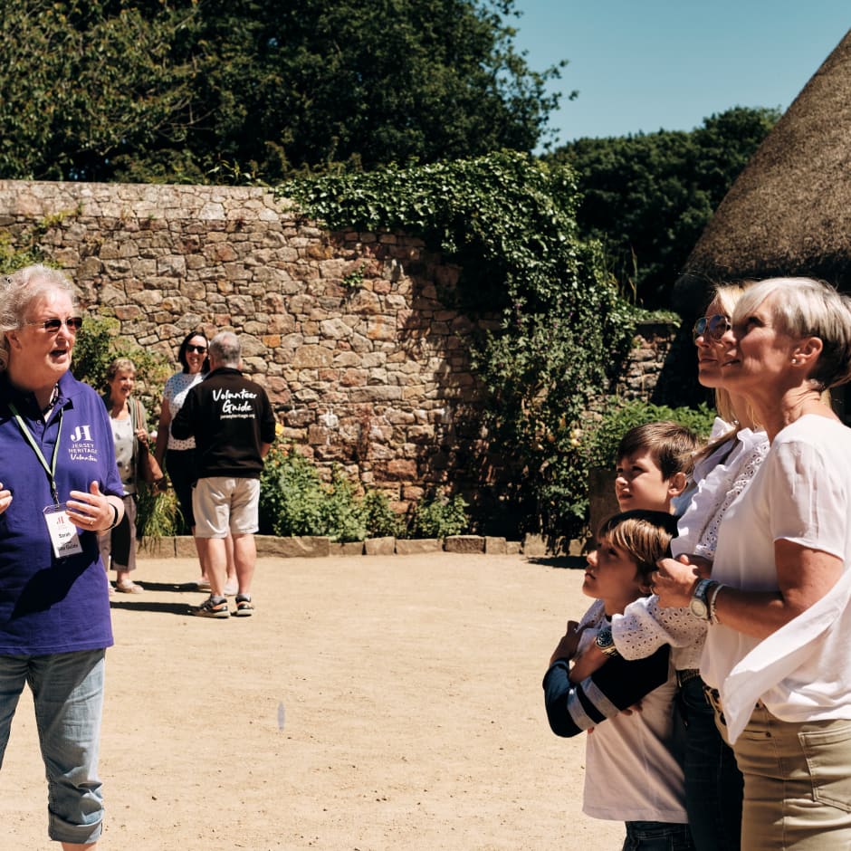 Hamptonne couple listen to a guide in farmyard