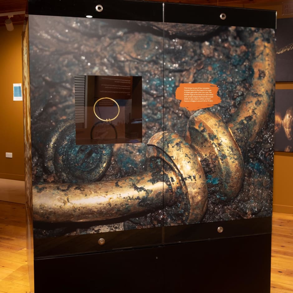 Display of gold torque with large image of torque at La Hougue Bie