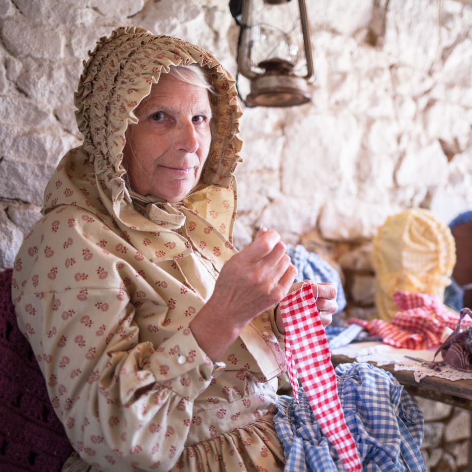 Women in 19 century clothing makes bonnets