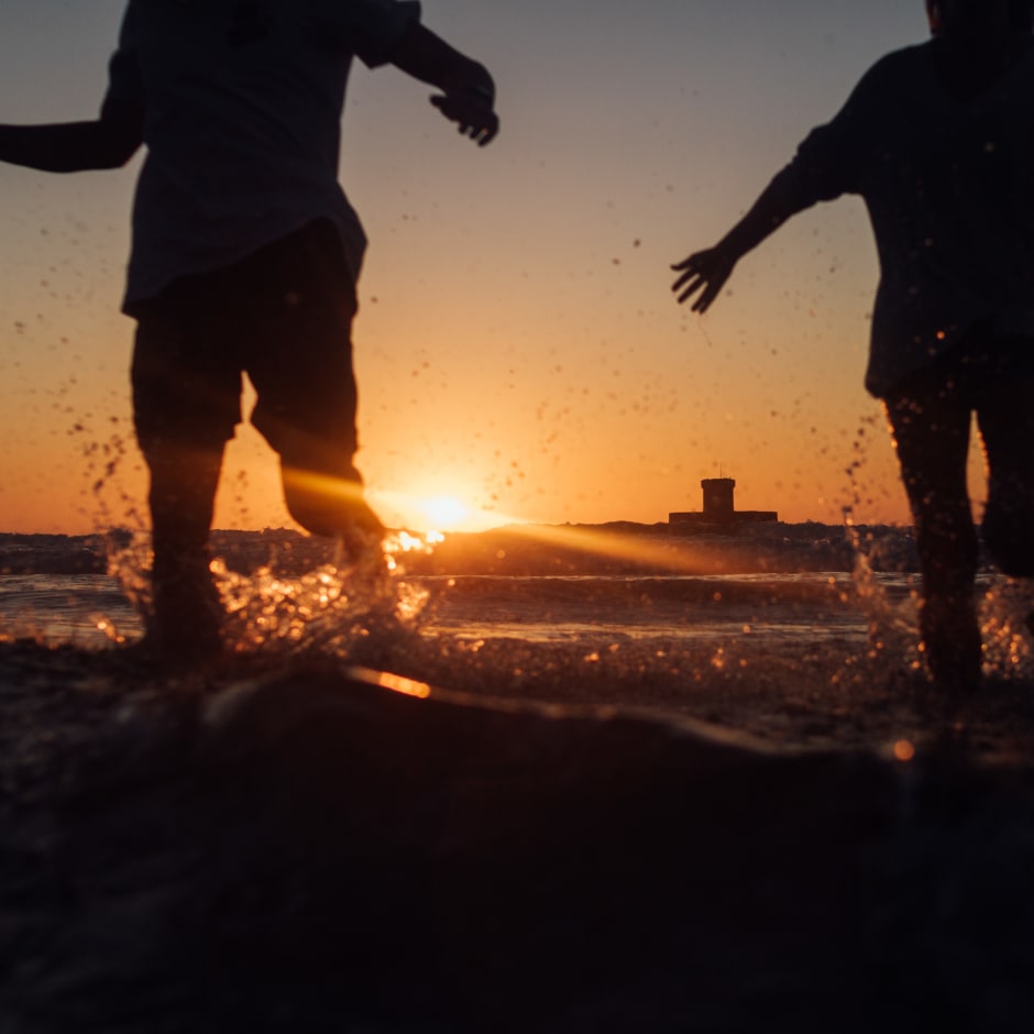 Two people running into the surf