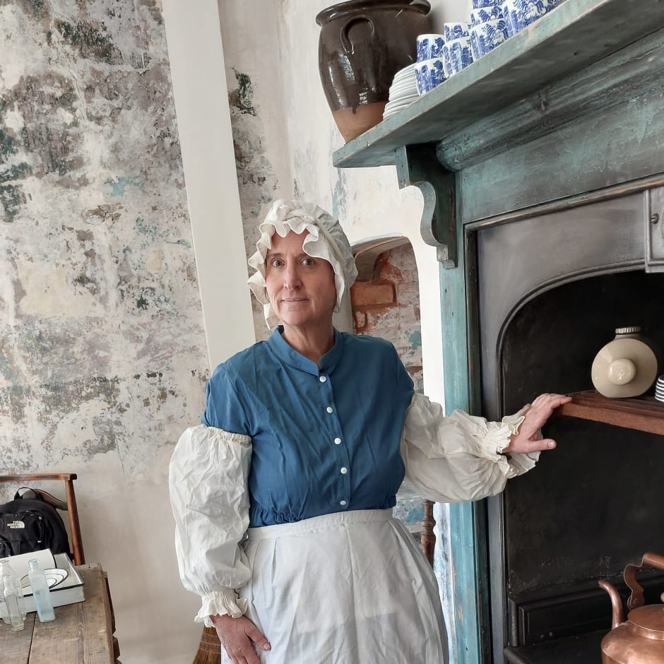 Woman stands by large range cooker.