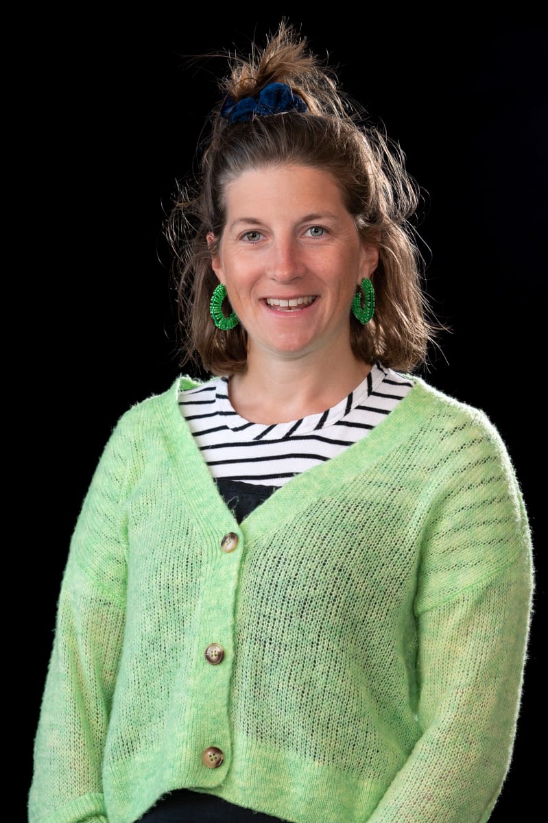 Woman in black and white top with green cardigan