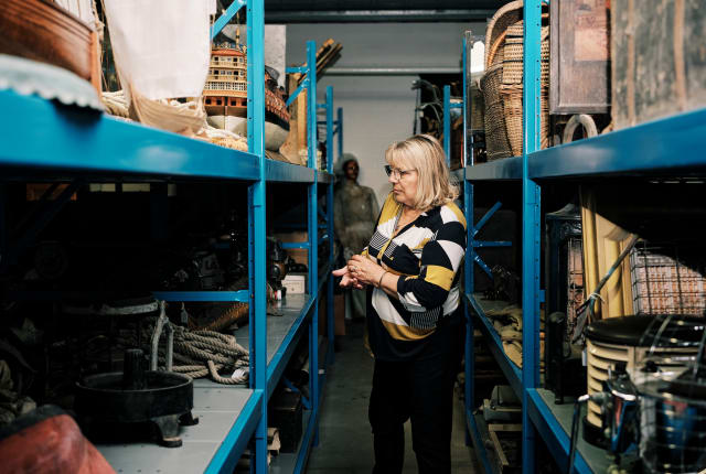 Sir Francis Cook women stands amongst lots of items