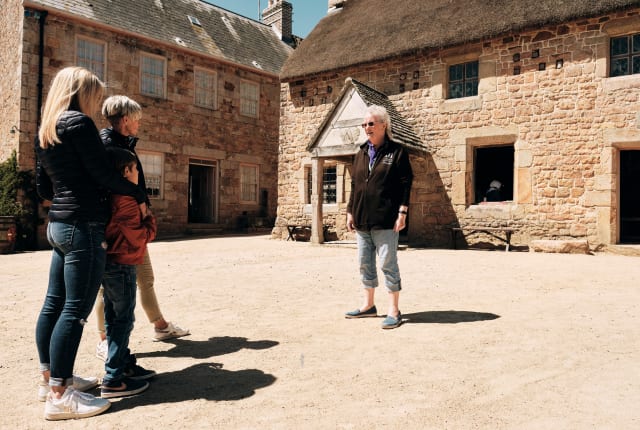 Hamptonne Couple listen to guide in courtyard