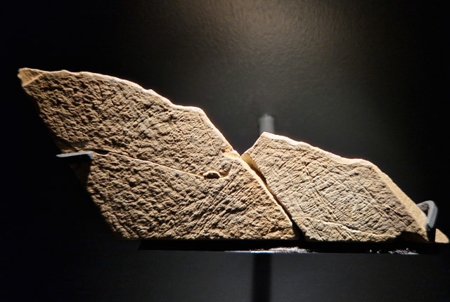 A stone with early line drawings otherwise known as a plaquette, highlighted with spot ligh