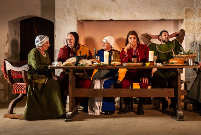 Group dressed in Medieval costume sit at large table