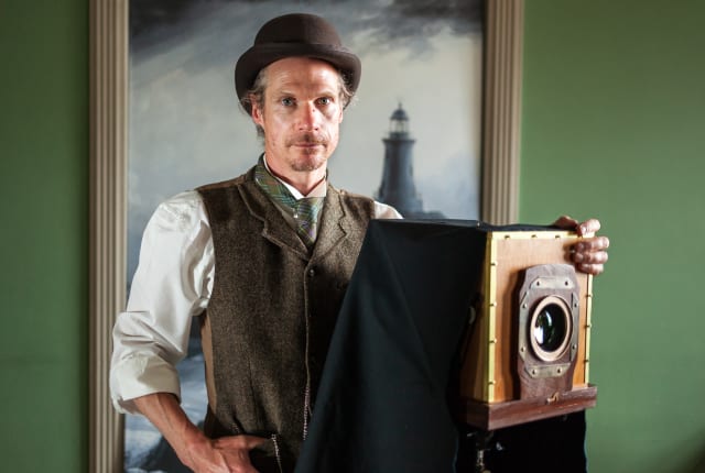 Man dressed in Victorian Clothes with old camera