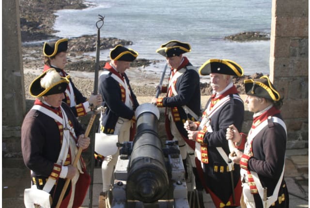 six uniformed men stand around a cannon