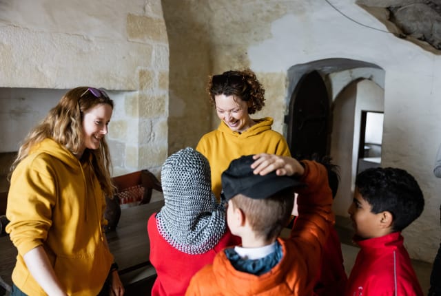 Two people talk to a small group of school children