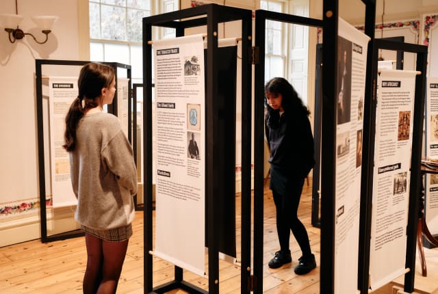 Two people look at exhibition panels