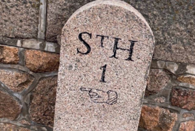 a granite marker which shows 1 mile to St Helier