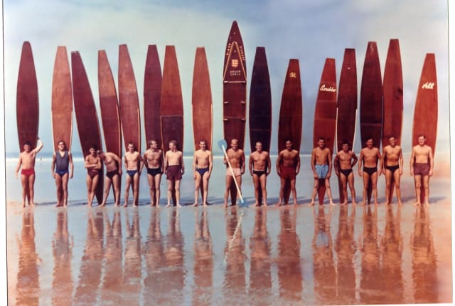 Group of male surfers with long boards