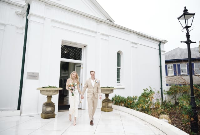 Young wedding couple outside a white building
