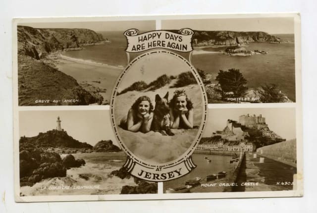 A black and white postcard with two girls and a dog in the middle