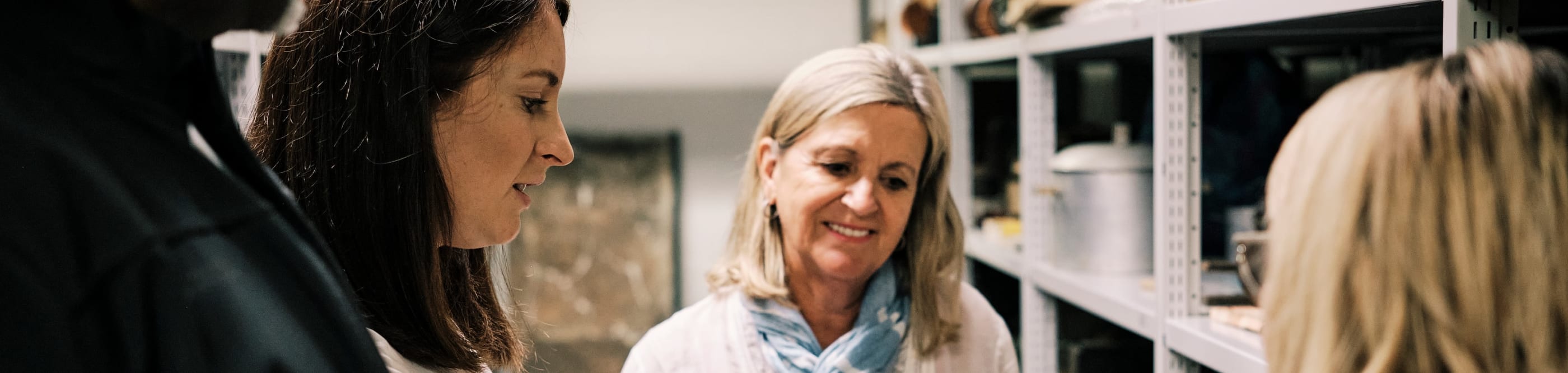 Sir Francis Cook woman holds red cross parcel for group to look at