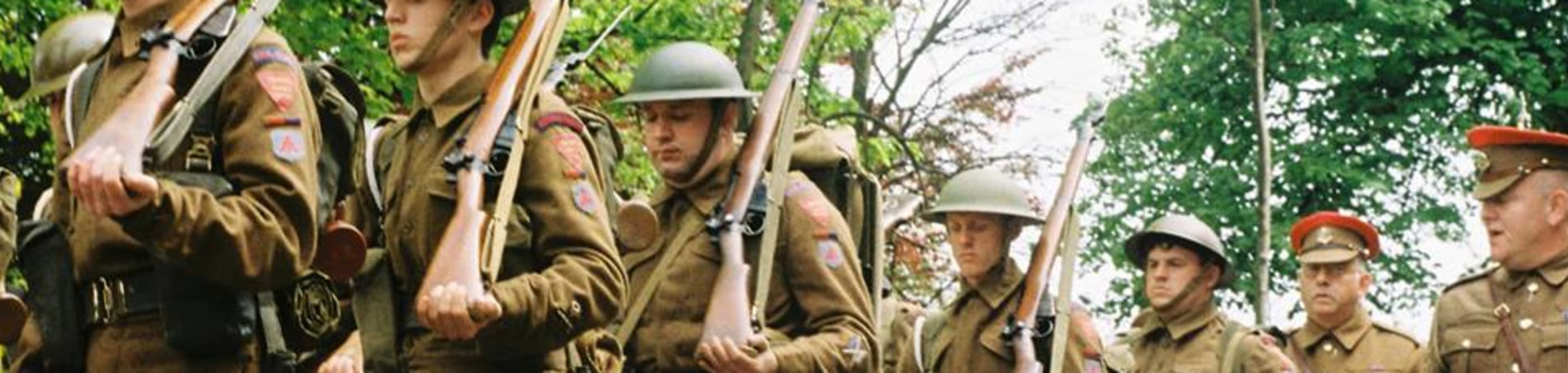 8 men dressed as British Tommys in 1945 uniform carry guns