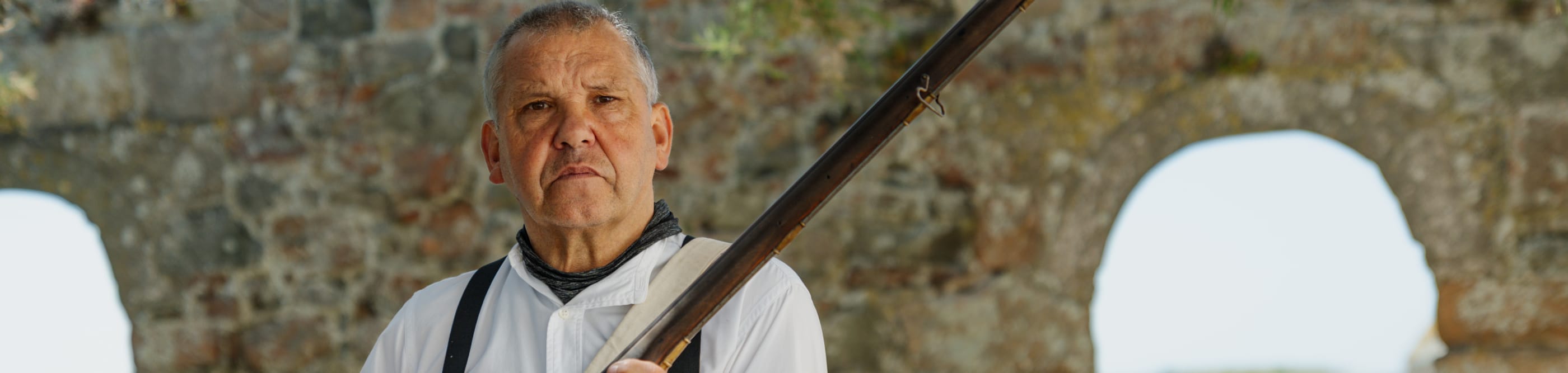 Man polishes fashioned rifle