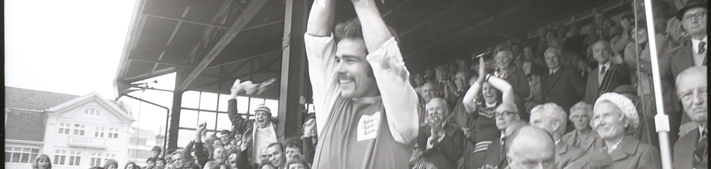 footballer holds trophy aloft.