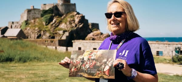 Elizabeth Castle women shows map of the Castle with Castle in background